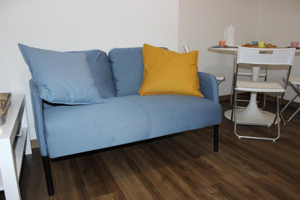 Un sofá azul con una almohada amarilla. en Lalla Home, en Bari