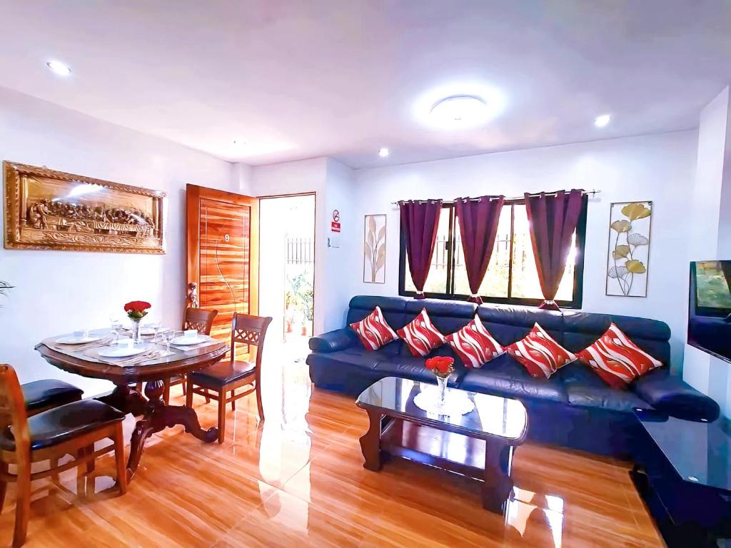 een woonkamer met een blauwe bank en een tafel bij 2 Bedroom Apartment ~ 5 Minutes to Grand Mall in Liloan