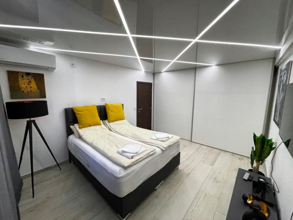 a bedroom with a bed with yellow pillows at Vip Lounge 63 in Belgrade