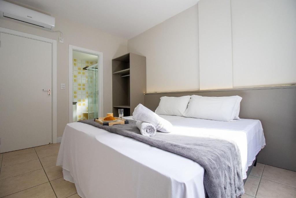 ein weißes Schlafzimmer mit 2 Betten und Handtüchern darauf in der Unterkunft STH52 - Quadra Mar, 4 Dorm, Centro, Climatizado in Balneário Camboriú