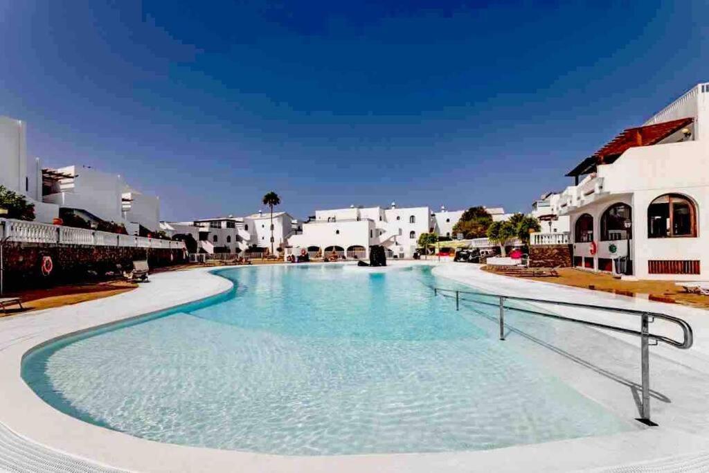 a large swimming pool in a resort with white buildings at Apartamento Casa Carmen Teguisol in Costa Teguise