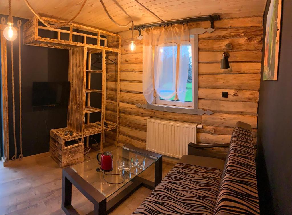 a living room with a couch and a table at Chatka Wagabundy in Wola Michowa