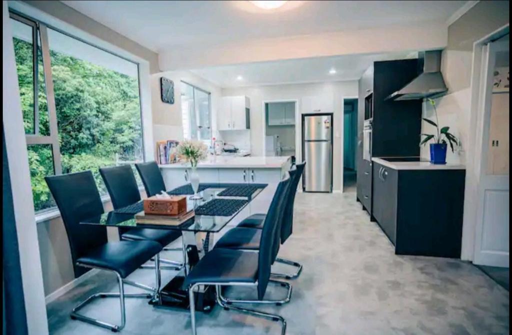 a kitchen and dining room with a table and chairs at Warm, tidy , quiet vacation home in Wellington