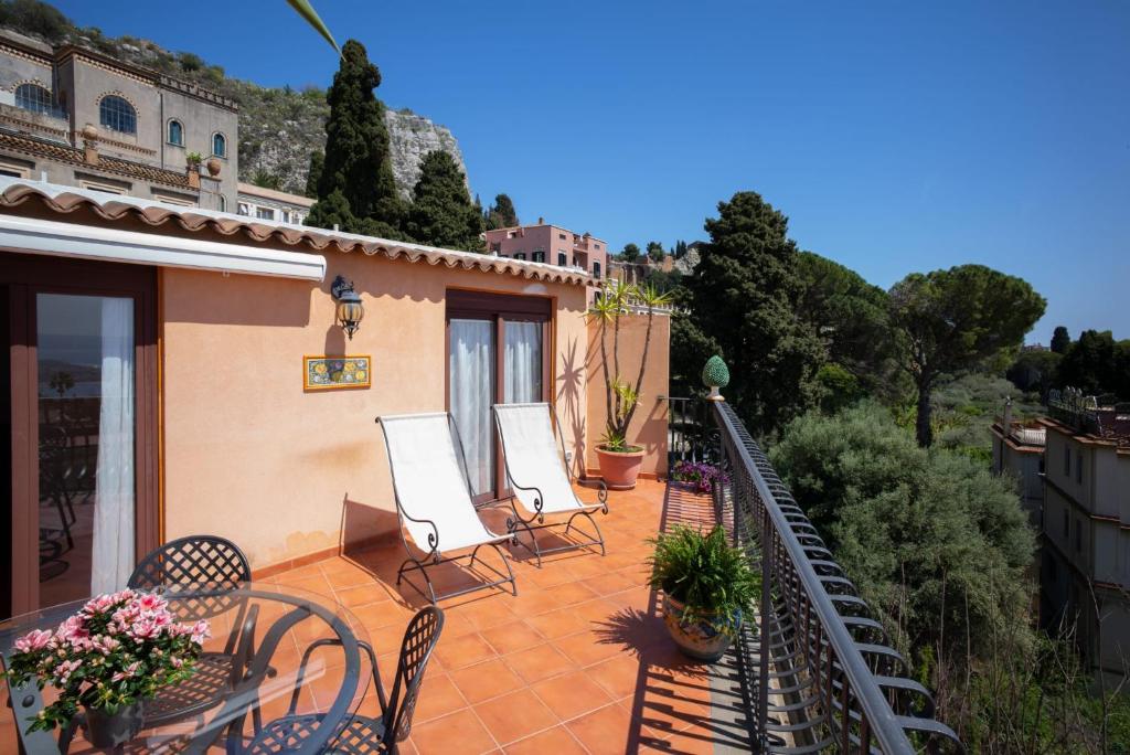 a balcony with chairs and tables on a house at B&B RE TANCREDI in Taormina