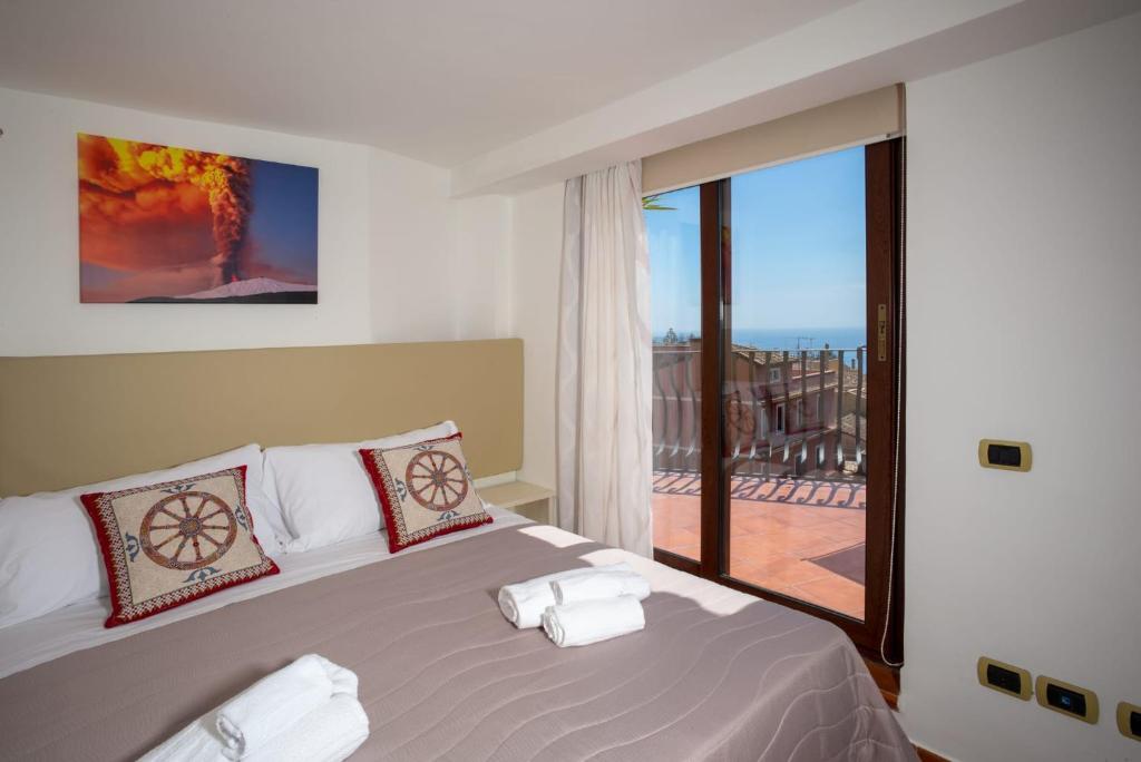 a bedroom with a bed and a large window at B&B RE TANCREDI in Taormina