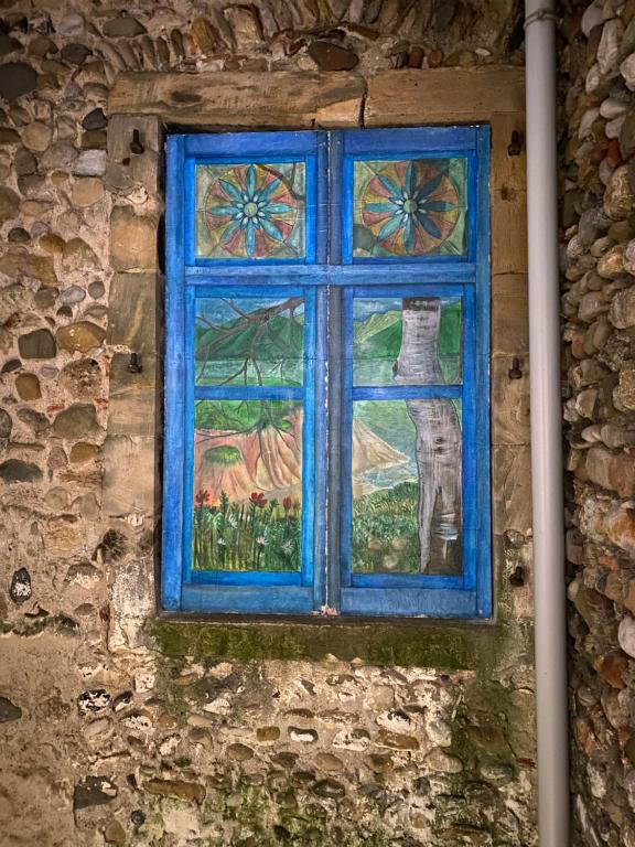 una ventana azul en el lateral de un edificio de piedra en Maison 2 minute de la place de la republique en Limoux
