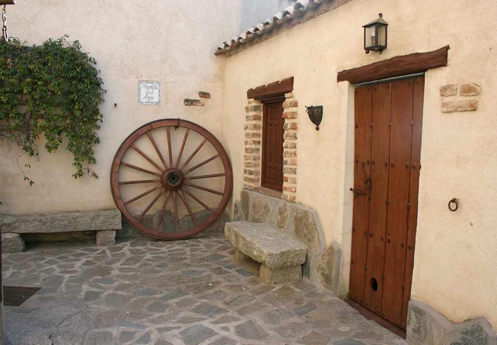 a building with a large wheel next to a door at Alojamientos Callejón del Pozo, cerca Puy du Fou in Gálvez