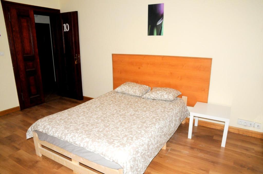 1 dormitorio con cama y cabecero de madera en Economic Mandala Apartment en Poznan