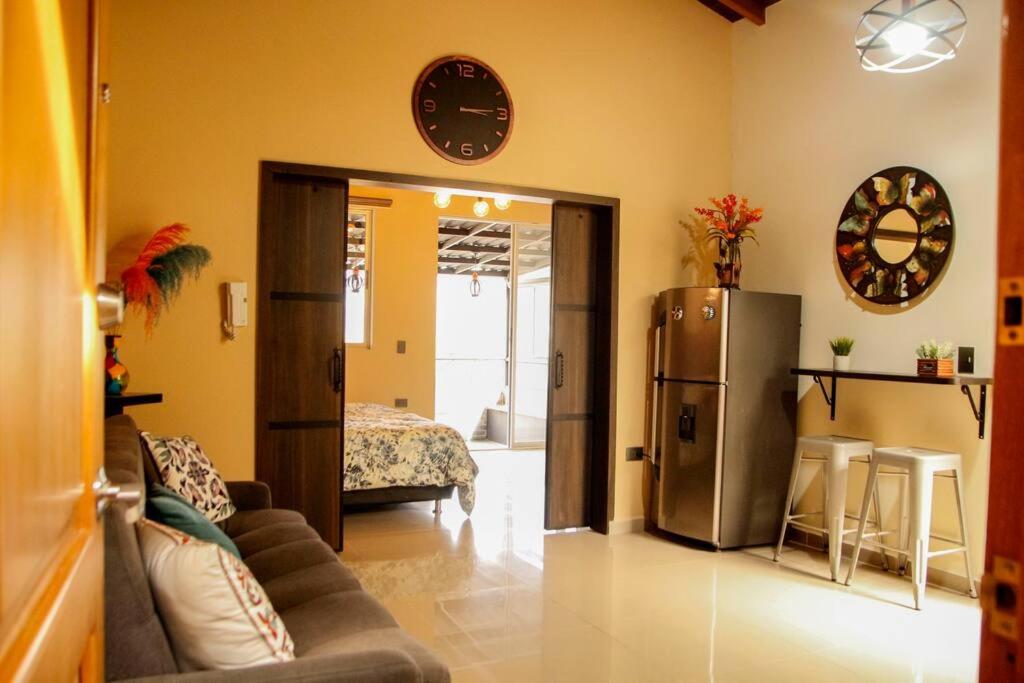a living room with a couch and a refrigerator at Lindo apartamento con terraza en Bello Ant in Bello