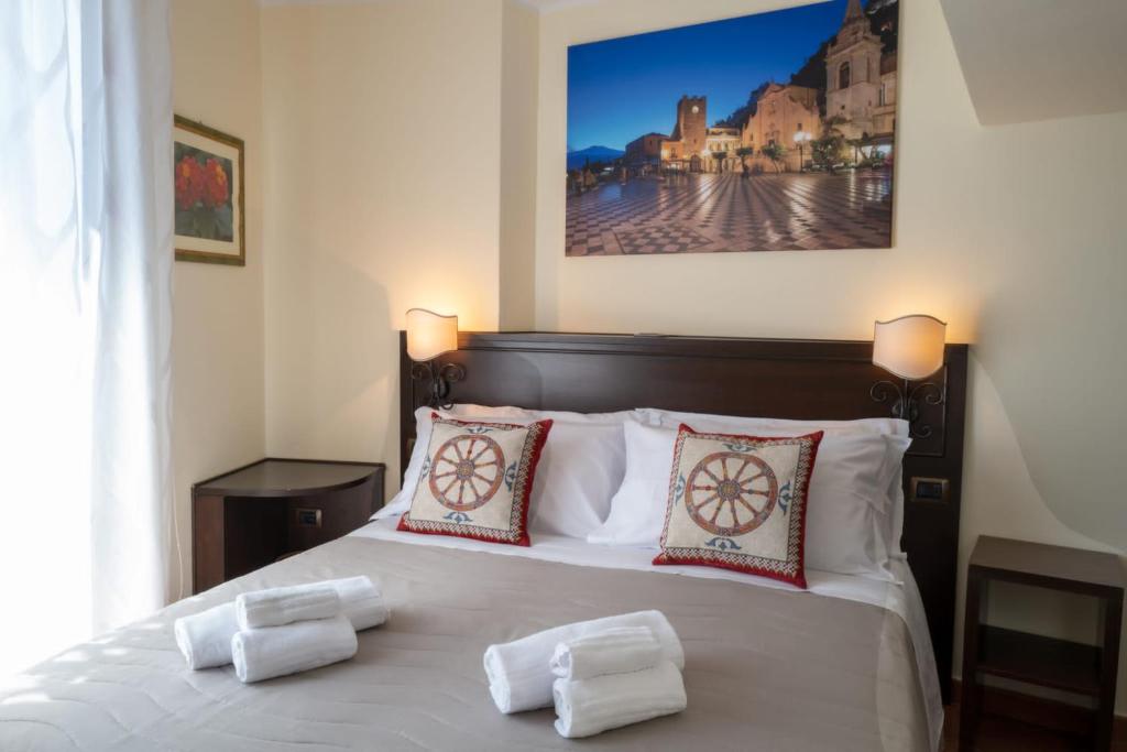 a bedroom with a bed with two pillows on it at B&B RE TANCREDI in Taormina