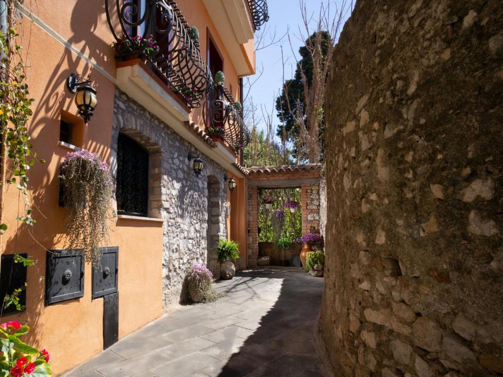 an alley in a building with a stone wall at B&B RE TANCREDI in Taormina