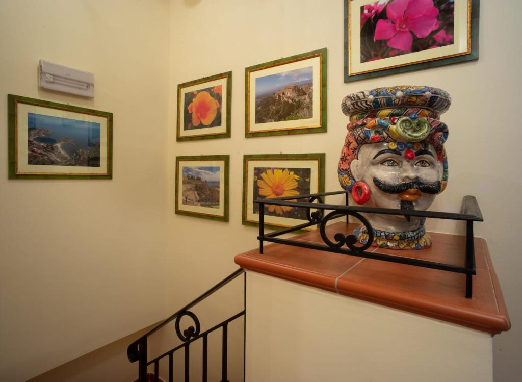 a large mask sitting on top of a stair case at B&B RE TANCREDI in Taormina