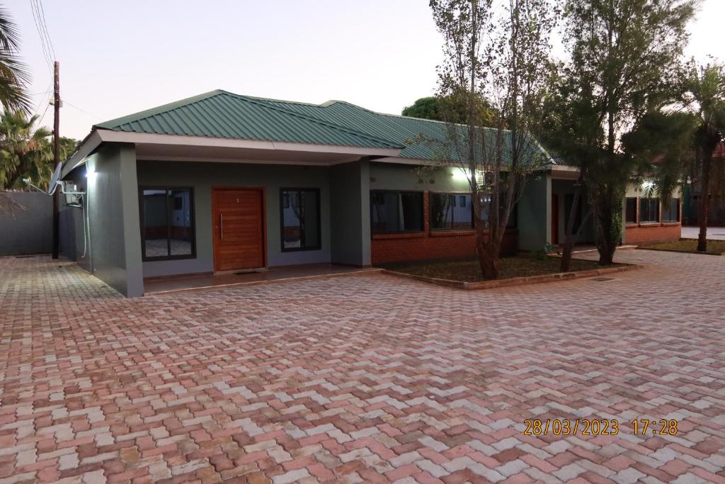 a house with a brick driveway in front of it at Lolani Apartments in Lusaka