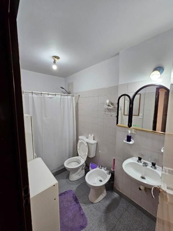 a bathroom with a toilet and a sink and a mirror at La Casa de Kuky in Esquel