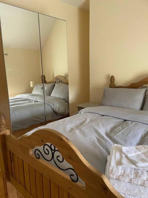 1 dormitorio con 2 camas y espejo en Stewarts House, en Newtownstewart