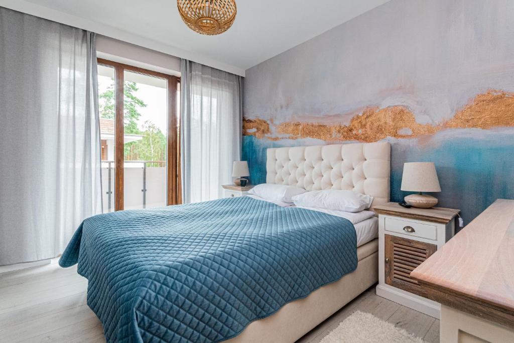 a bedroom with a bed and a painting on the wall at Apartament Stegna Marine in Stegna