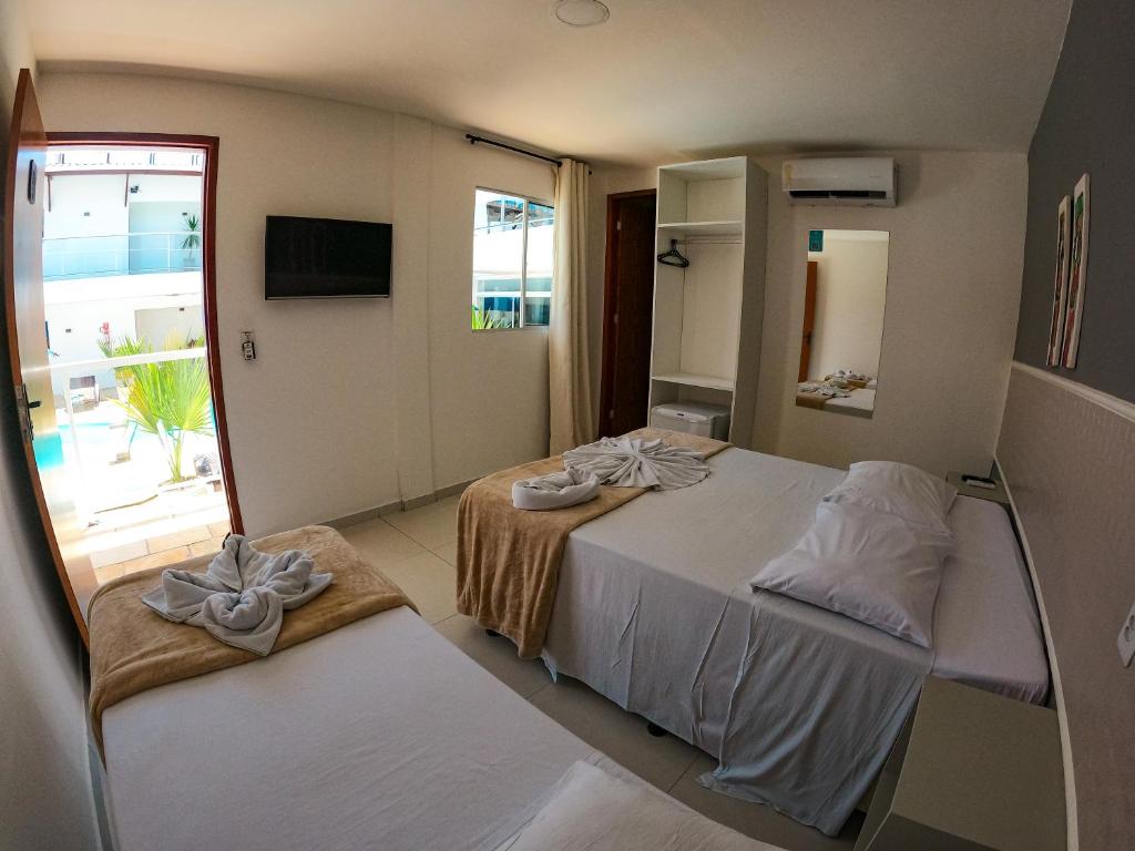 - une chambre avec 2 lits et des serviettes dans l'établissement Vila de Maré Hotel, à Porto de Galinhas