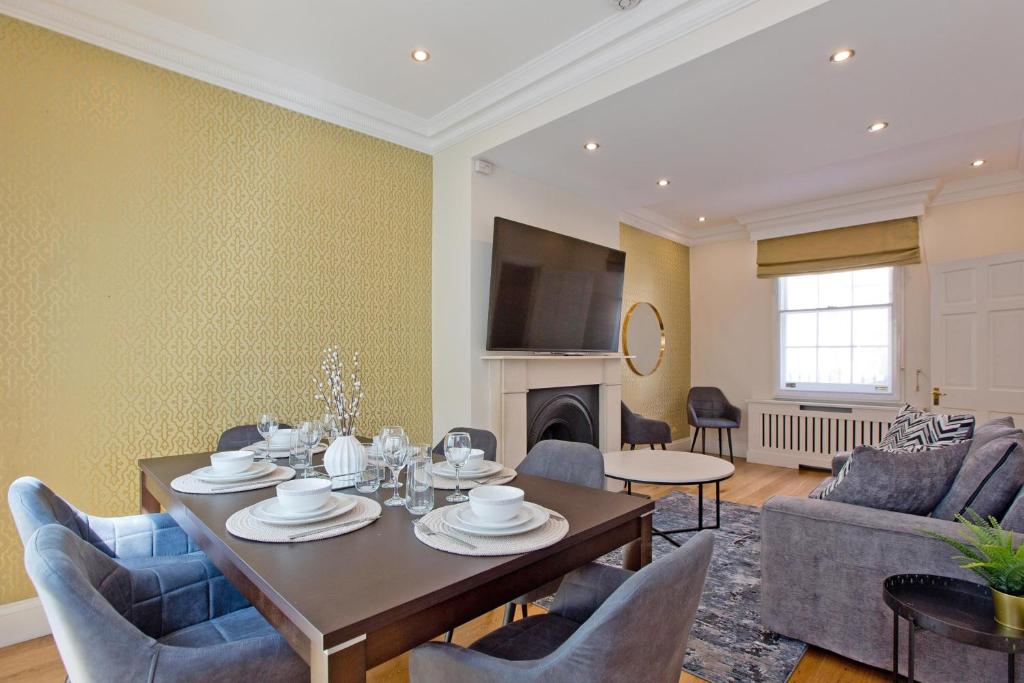 a living room with a table and chairs at Hyde Park Paddington spacious London Home in London
