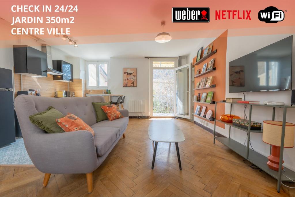 een woonkamer met een bank en een tafel bij Appartement T3 63m2 - L'Atypique et son Jardin de 350m2 au cœur de Digne in Digne-les-Bains