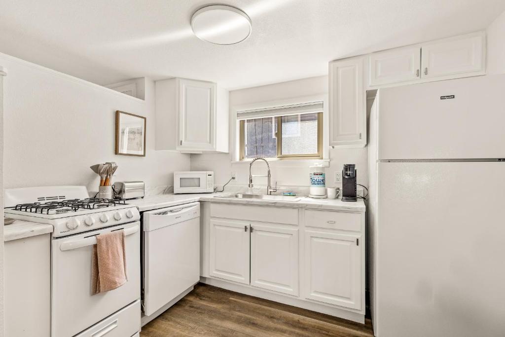 uma cozinha com armários brancos e um frigorífico branco em Venture at Route 66 em Flagstaff