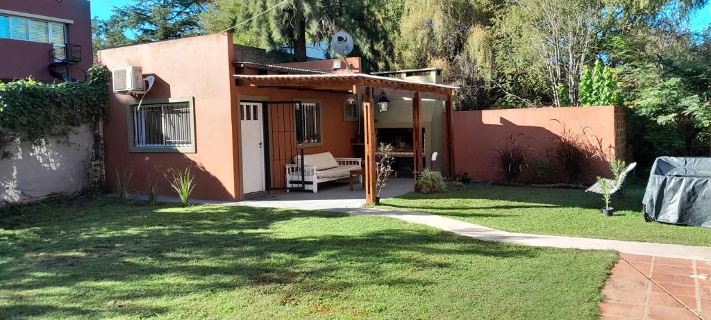 une maison avec une terrasse et une pelouse dans l'établissement La Adelita, à Chascomús