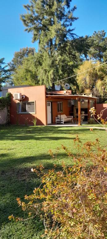 a house in a yard with a green lawn at La Adelita in Chascomús