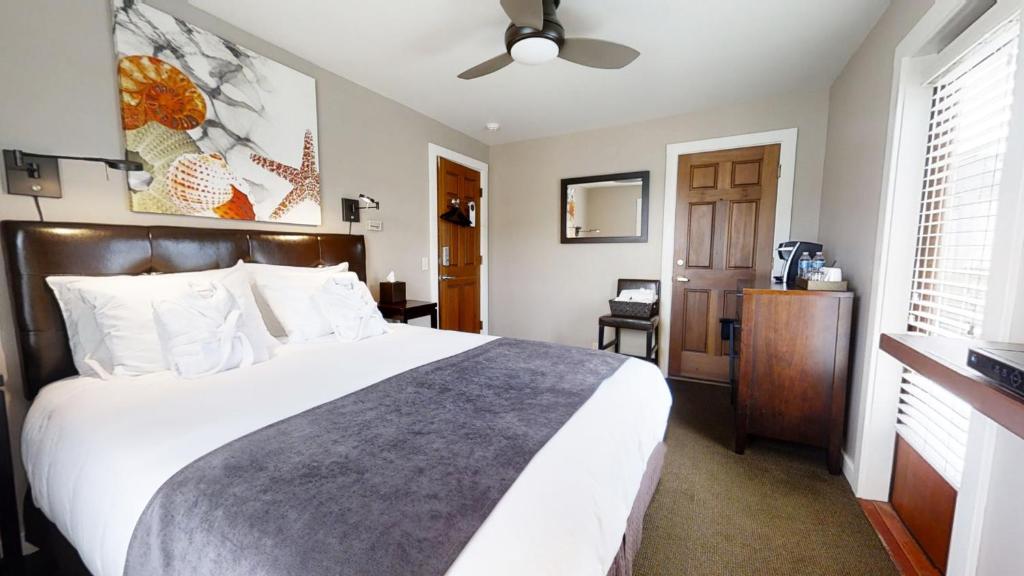 um quarto com uma grande cama branca e uma janela em Bird Rock Hotel em Friday Harbor