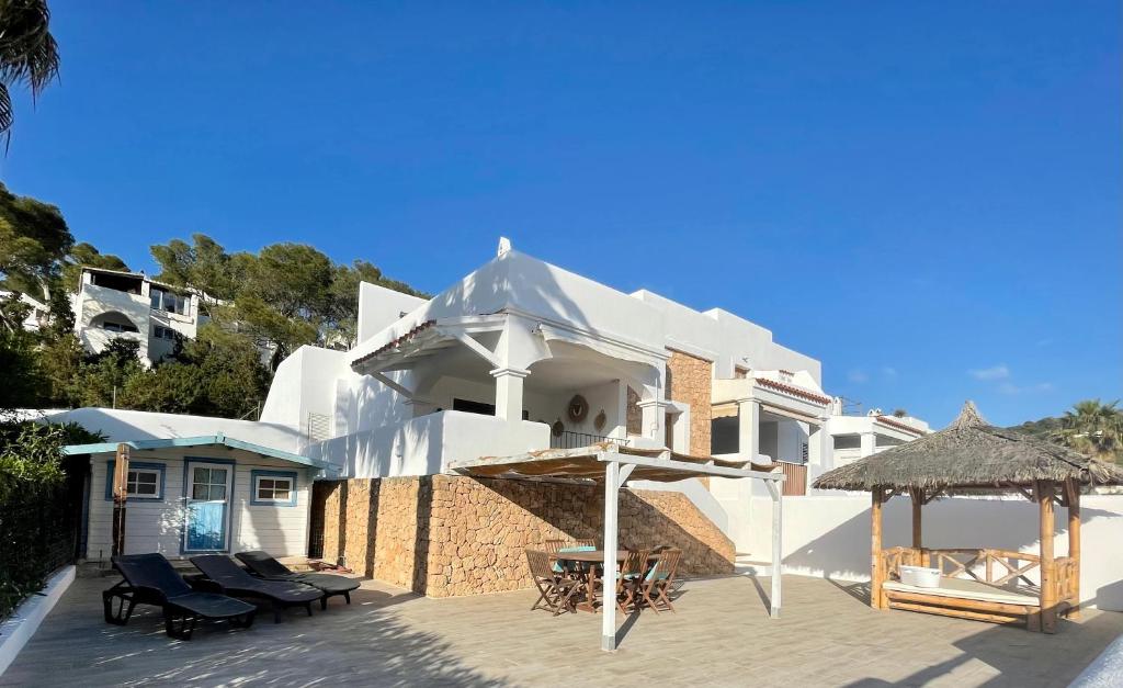 ein weißes Haus mit einer Terrasse und einem Pavillon in der Unterkunft Casa Maria Sunset in Cala Vadella