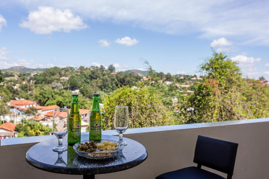ein Tisch mit Weinflaschen und Gläsern auf einem Balkon in der Unterkunft Home Of The Day - Hospedagem in Cunha
