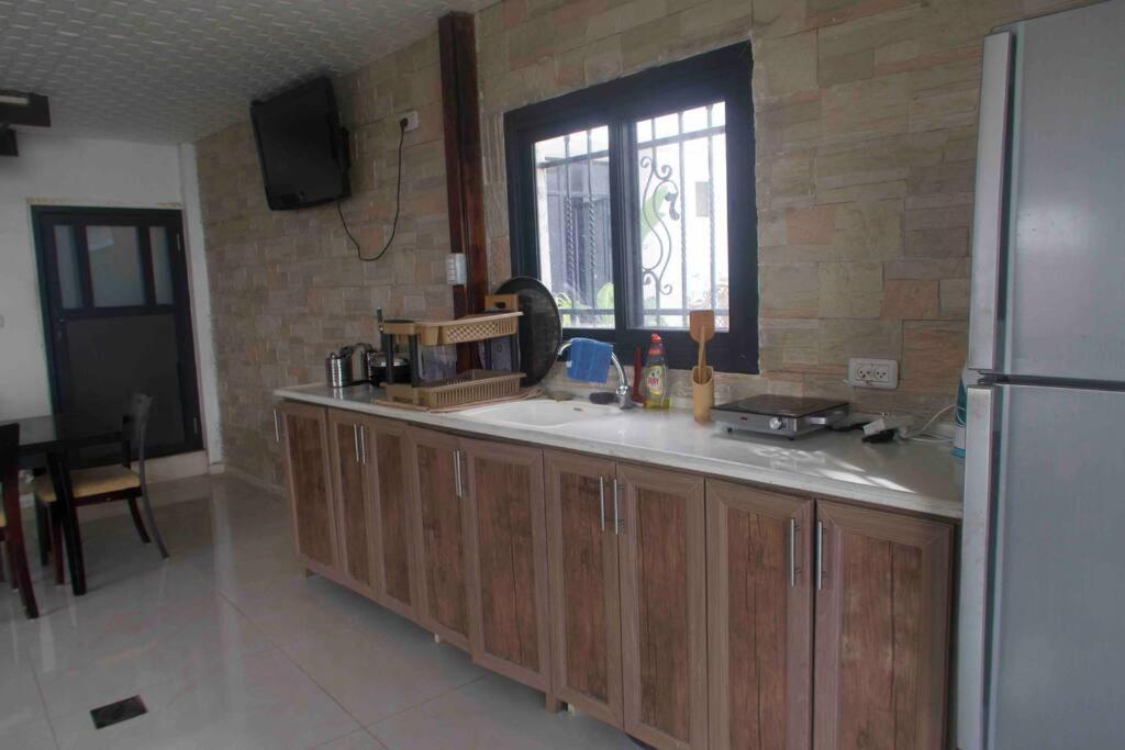 a kitchen with wooden cabinets and a refrigerator at Jericho Palestine, Panorama Villa- View, Full Privacy & Pool in Jericho