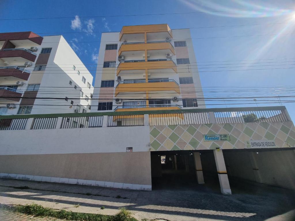 un edificio alto con un garaje frente a él en TH 3102 - Flat de 2 quartos com varanda en Governador Valadares