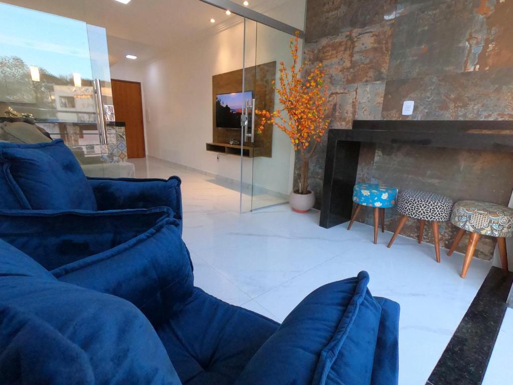 uma sala de estar com um sofá azul e uma lareira em TH Flats GV Shopping 502 em Governador Valadares