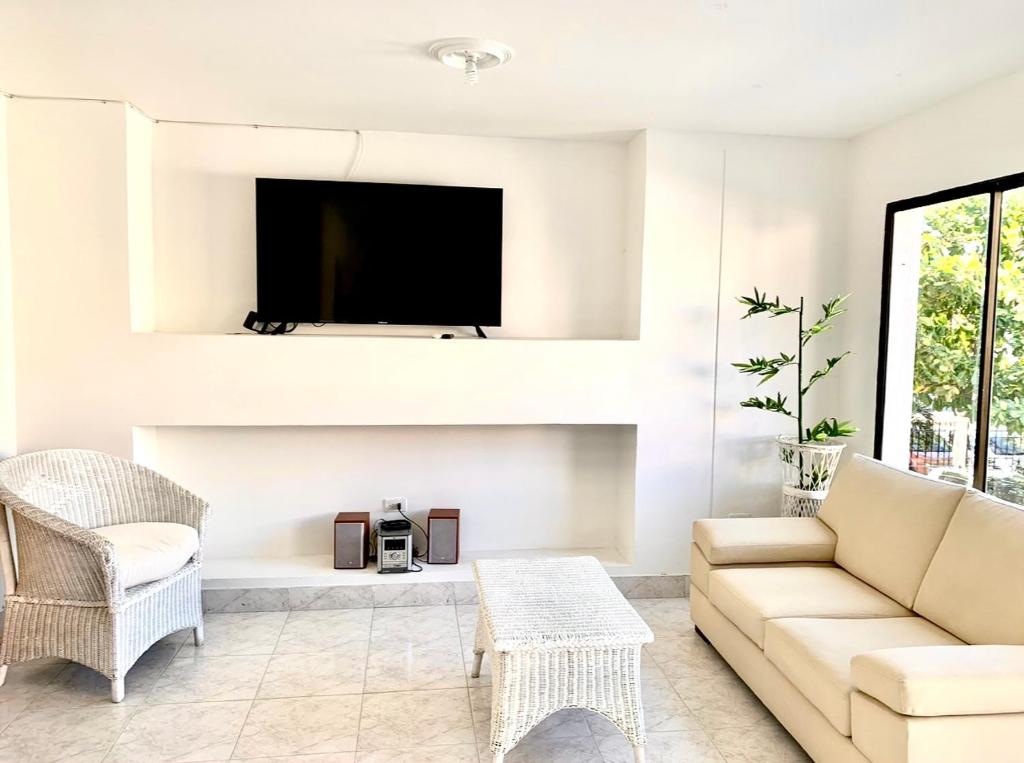 - un salon avec un canapé et une télévision dans l'établissement Apartamento en el Rodadero, muy bien ubicado, à Gaira
