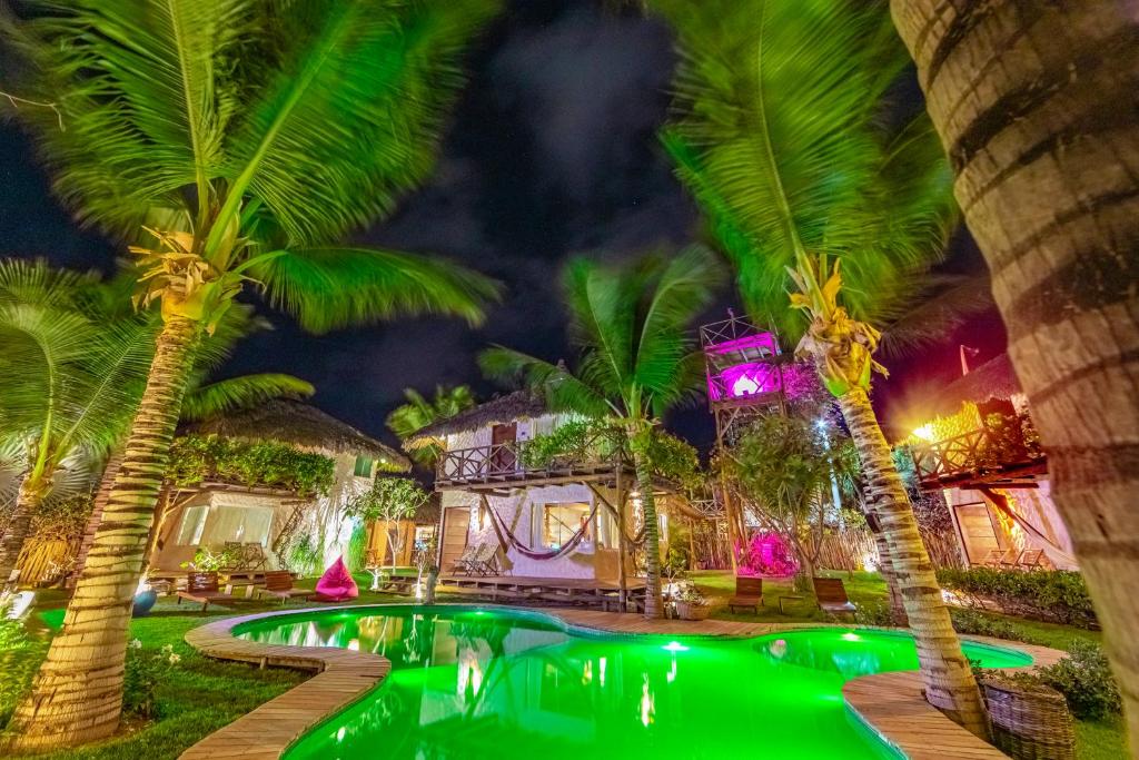 een zwembad voor een huis met palmbomen bij Vilarejo Barra Grande in Barra Grande