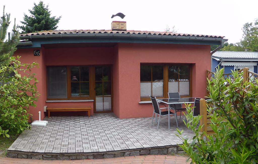 a small red house with a patio and a table at Haus Seebrise in Wustrow