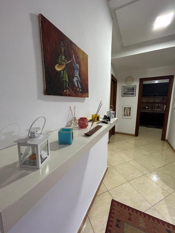 a kitchen with a counter with a painting on the wall at chambre privée in Kenitra