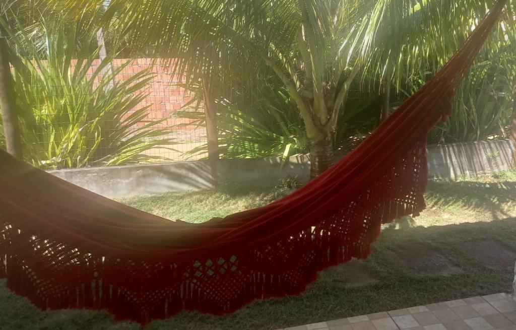 a hammock in a garden with palm trees at Casa na Praia de Saquaira - Península de Maraú. in Marau