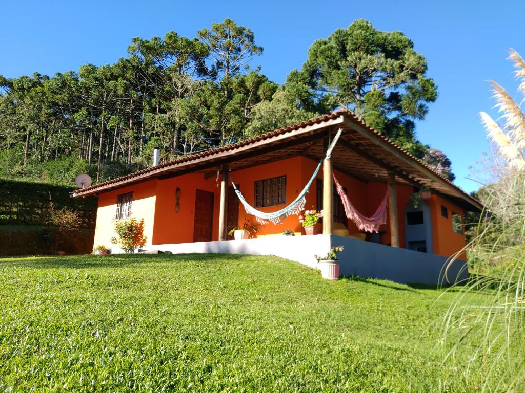 ein Haus mit grünem Rasen davor in der Unterkunft Casa Aconchegante Na Mantiqueira in Gonçalves