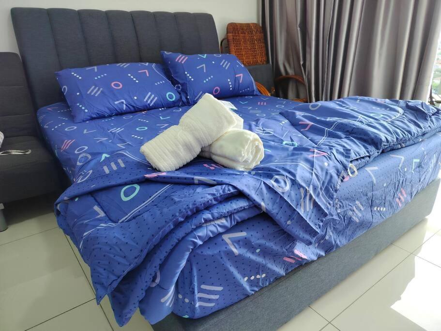 安邦的住宿－Ampang 2-4 pax Studio AmpPoint，床上的蓝色棉被和枕头