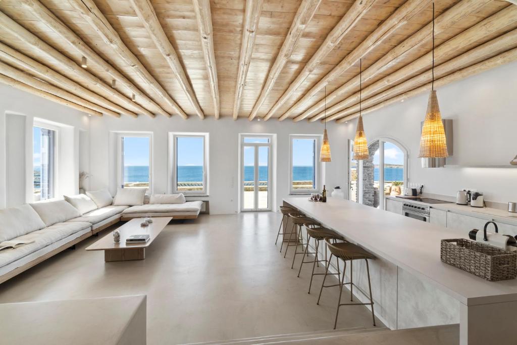 a kitchen and living room with a long island at Villa Gaia, Beachfront, Plunge Pool & Sunset by Explore Andros in Apróvaton
