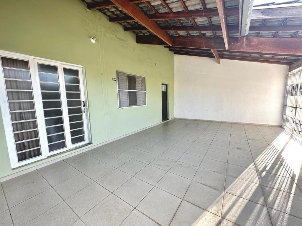 ein leeres Zimmer mit einer grünen Wand und Fenstern in der Unterkunft Sonho meu in Guaratinguetá