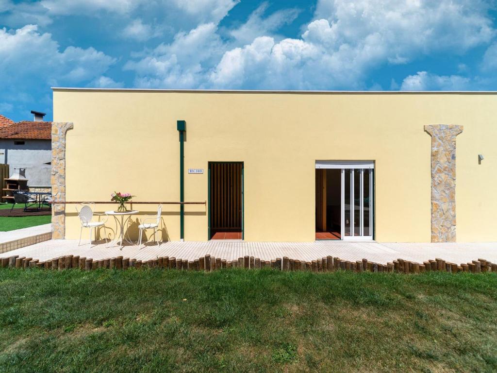 um edifício com uma mesa e cadeiras em frente em Rural holiday home in Netos Almagreira with shared pool 