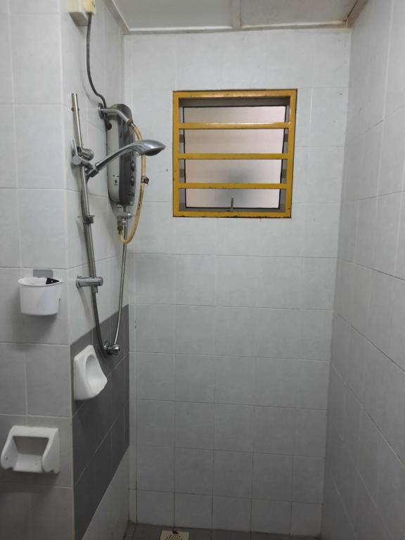 een badkamer met een douche en een raam bij Homestay cikgu in Kamunting