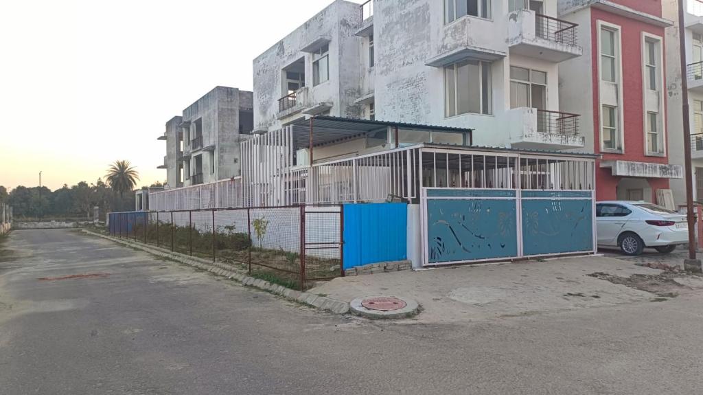 een gebouw met een blauwe poort naast een straat bij Asha Home Stay Ansal Golf City in Lucknow