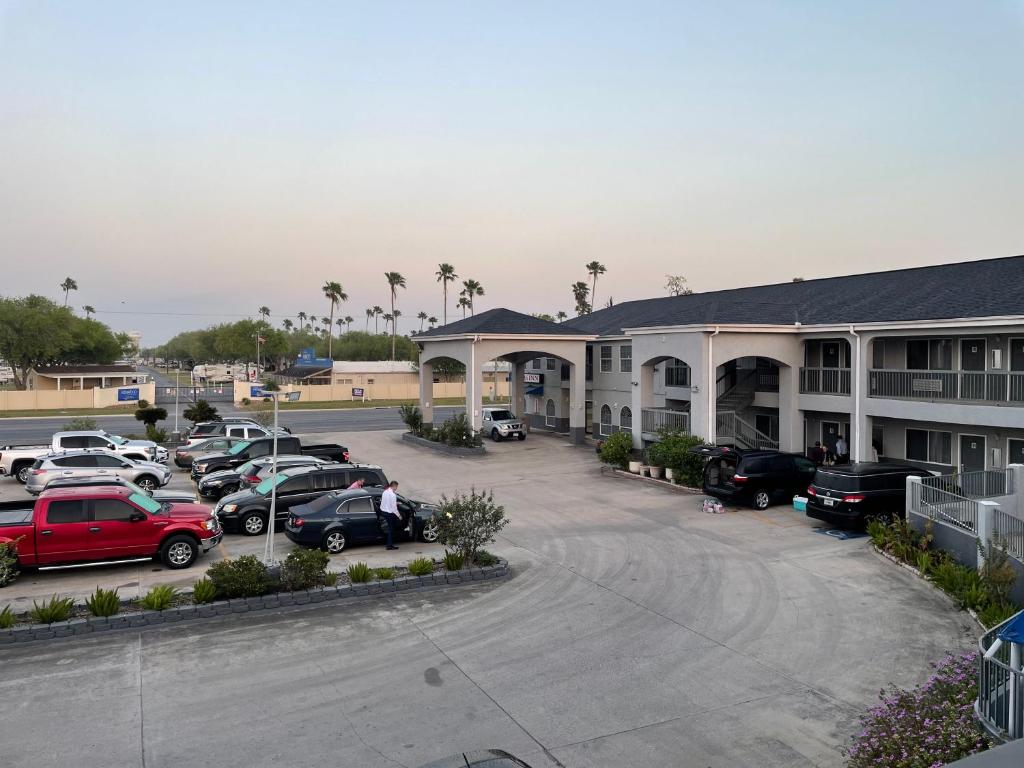 a parking lot with cars parked in front of a hotel at Texas Inn La Feria in La Feria