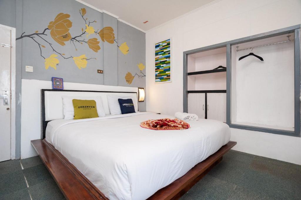 a bedroom with a large white bed with a bowl on it at Urbanview Hotel Ananda Syariah by RedDoorz in Bukittinggi