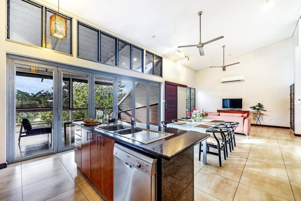 a kitchen with a counter and a table with chairs at 'Troppo' Darwin Designer Luxury Boutique Home in Paraparap