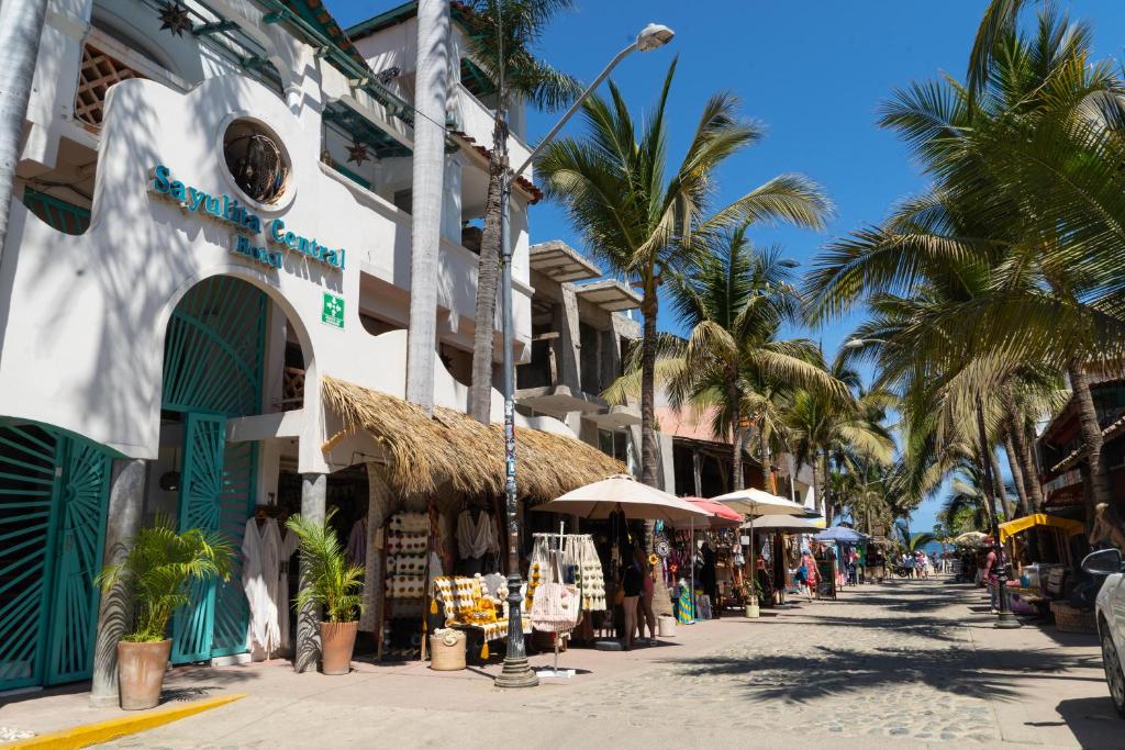 a street in front of a building with palm trees at Sayulita Central Hotel in Sayulita