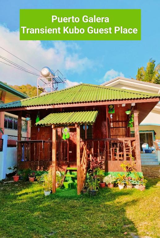 a guest house in a resort with a green roof at Puerto Galera Transient Kubo Guest Place in Puerto Galera