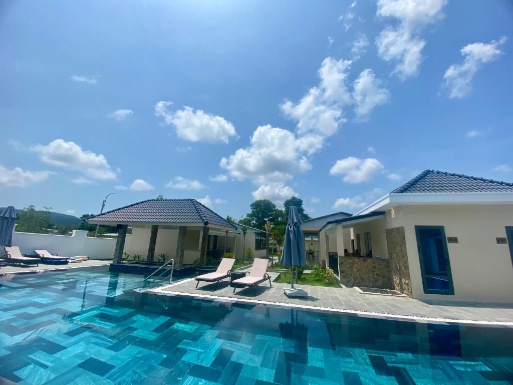 a view of a swimming pool with chairs and umbrellas at LAM BUNGALOW Resort & Spa in Phú Quốc